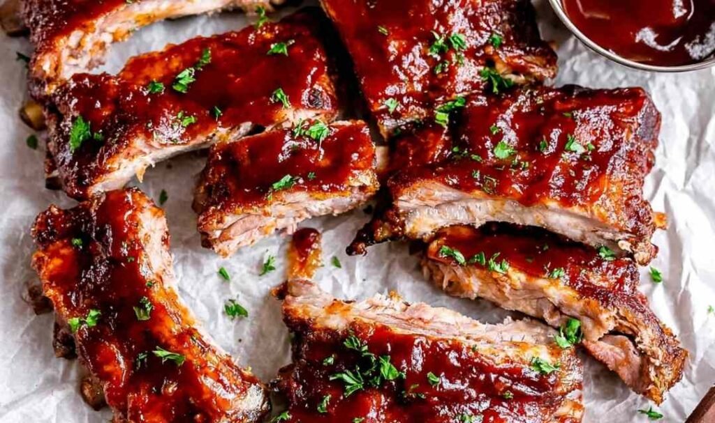 Fall-off-the-bone Instant Pot Ribs glazed with caramelized BBQ sauce on parchment paper