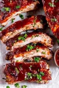 Fall-off-the-bone Instant Pot Ribs glazed with caramelized BBQ sauce on parchment paper