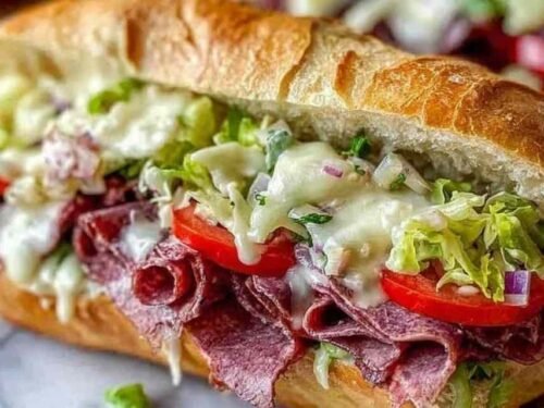 Close-up of an Italian Grinder Salad Sandwich stacked with deli meats and tangy chopped salad on a toasted sub roll