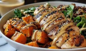 Maple Dijon chicken sweet potato bowls with glazed roasted chicken and golden sweet potatoes in a white baking dish