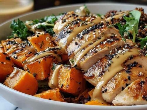 Maple Dijon chicken sweet potato bowls with glazed roasted chicken and golden sweet potatoes in a white baking dish