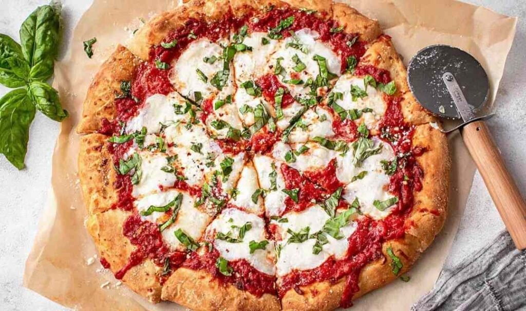 Classic margherita pizza with fresh mozzarella, San Marzano tomato sauce, and fresh basil on a golden crispy crust baked at home