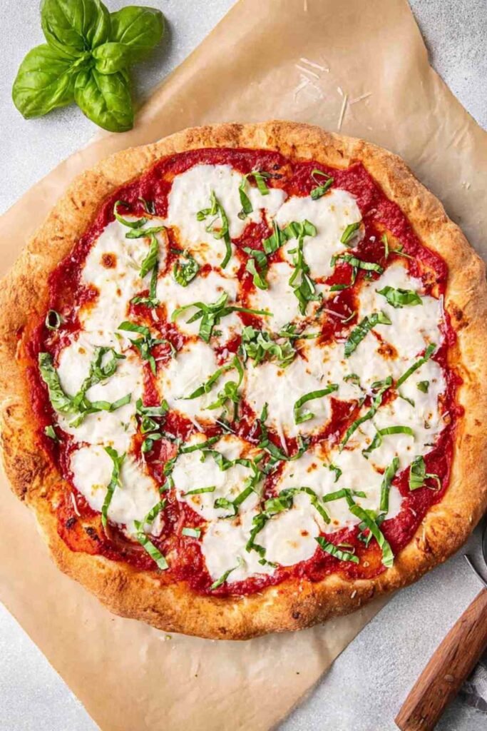 Classic margherita pizza with fresh mozzarella, San Marzano tomato sauce, and fresh basil on a golden crispy crust baked at home