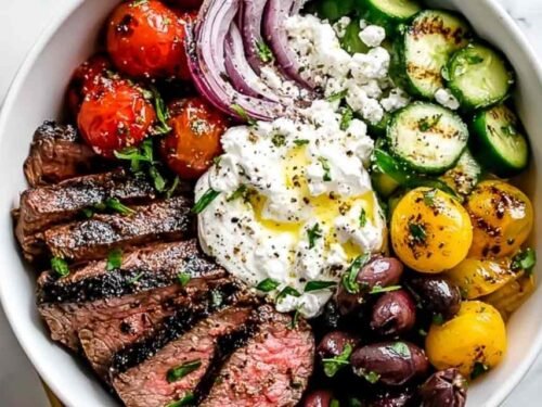 Mediterranean Steak Bowl with sliced grilled sirloin, cherry tomatoes, cucumber, kalamata olives, feta, and homemade tzatziki over brown rice