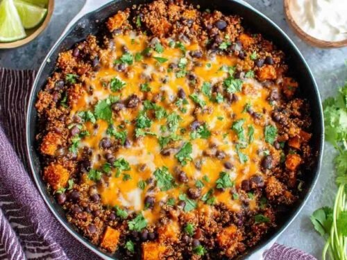 Mexican Quinoa Skillet with sweet potatoes, black beans, melted cheddar cheese, and fresh cilantro in a large skillet