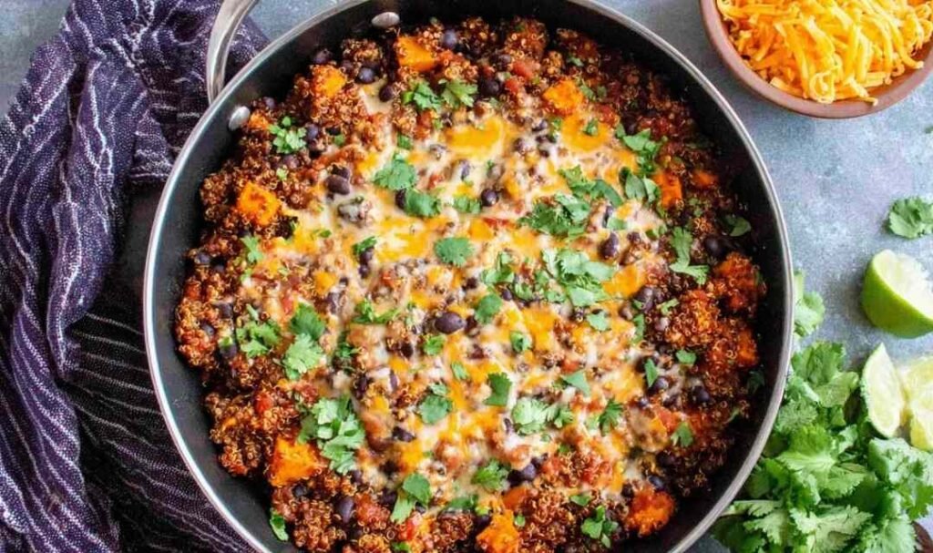 Mexican Quinoa Skillet with sweet potatoes, black beans, melted cheddar cheese, and fresh cilantro in a large skillet