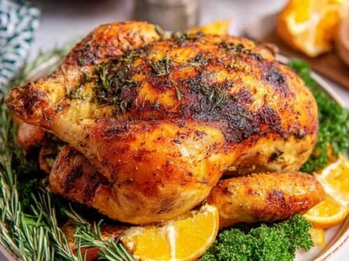 Easy roast chicken with crispy golden skin resting in a cast iron skillet with roasted vegetables