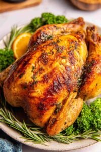 Easy roast chicken with crispy golden skin resting in a cast iron skillet with roasted vegetables