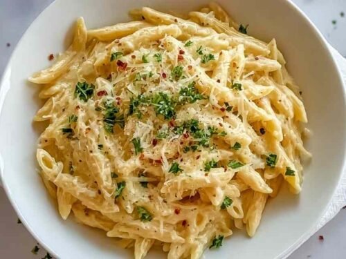 One pot creamy garlic pasta in a large skillet topped with freshly grated Parmesan and chopped parsley ready to serve