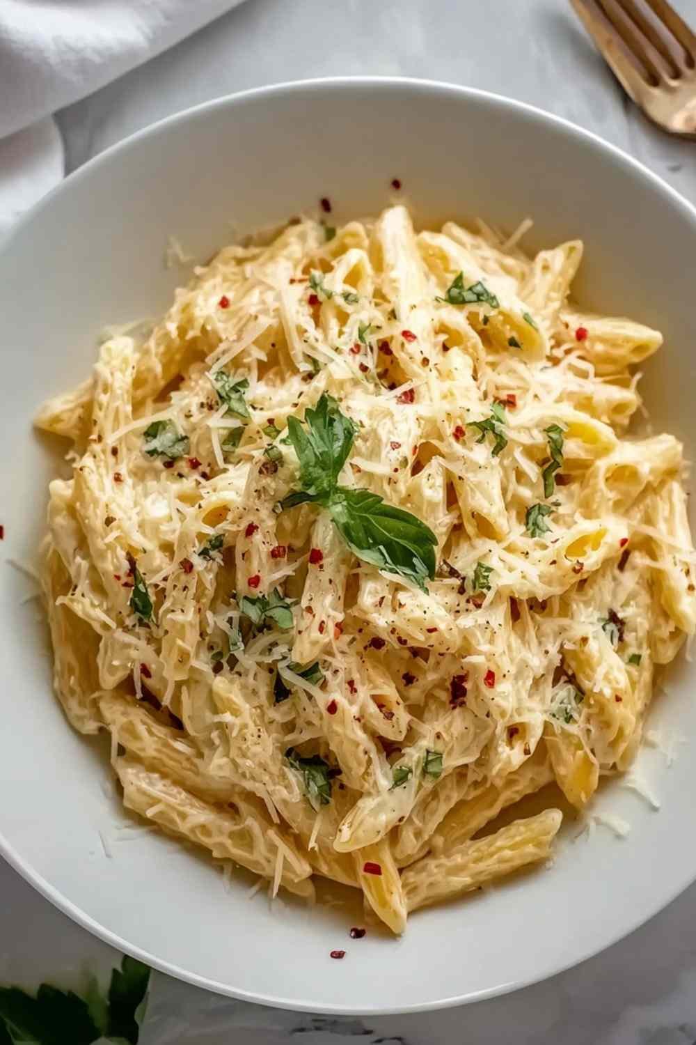 One pot creamy garlic pasta in a large skillet topped with freshly grated Parmesan and chopped parsley ready to serve