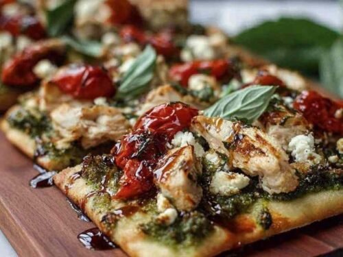 Pesto chicken flatbread baked with melted mozzarella, cherry tomatoes, and fresh basil on golden crispy naan
