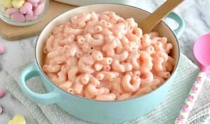 Creamy pink mac and cheese in a white bowl made with natural beet juice dairy-free
