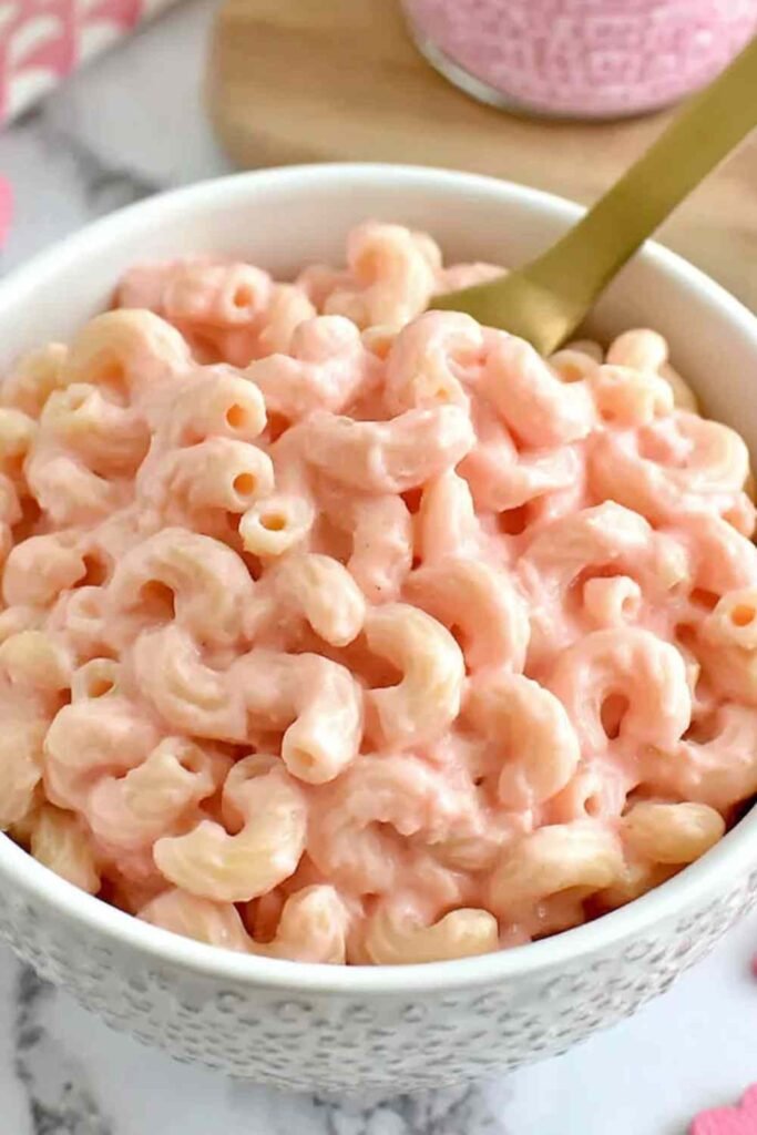 Creamy pink mac and cheese in a white bowl made with natural beet juice dairy-free