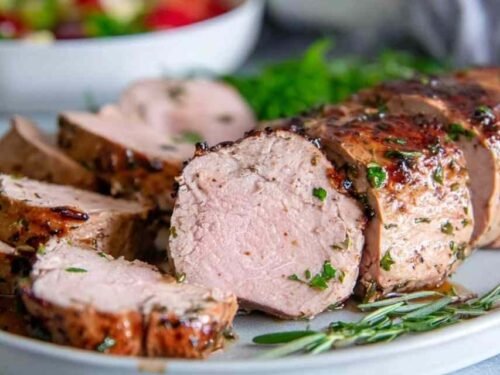 Juicy sliced pork tenderloin made with a garlic soy pork tenderloin marinade on a white plate