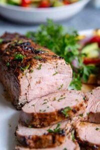Juicy sliced pork tenderloin made with a garlic soy pork tenderloin marinade on a white plate