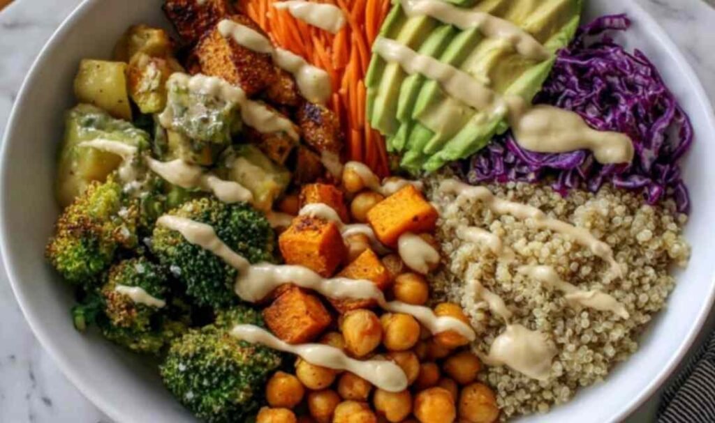 Colorful vegan Buddha bowl with quinoa, chickpeas, roasted sweet potato, broccoli, and tahini dressing