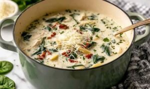 Creamy quick white lasagna soup in a white bowl topped with melted mozzarella and fresh basil