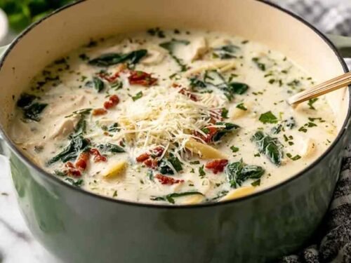 Creamy quick white lasagna soup in a white bowl topped with melted mozzarella and fresh basil
