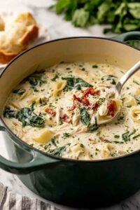 Creamy quick white lasagna soup in a white bowl topped with melted mozzarella and fresh basil