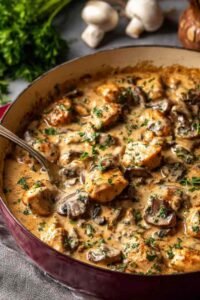 Rich chicken stroganoff in a skillet with creamy mushroom sauce and golden seared chicken pieces