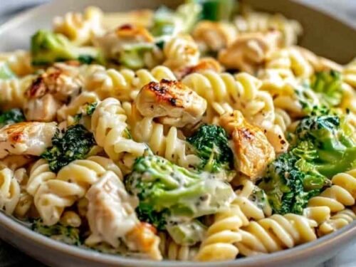 Creamy rotisserie chicken broccoli pasta in a white bowl with Parmesan sauce, tender shredded chicken, and broccoli florets