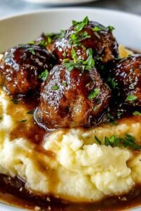 Salisbury Steak Meatballs served over creamy garlic herb mashed potatoes with rich beef gravy and fresh parsley