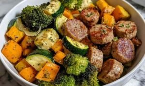 Sausage veggie skillet bowl cooking in a large skillet with chicken sausage coins, broccoli florets, zucchini slices, and sweet potato cubes