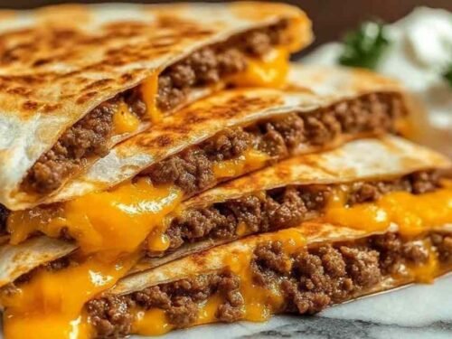 Smashburger quesadillas sliced into wedges served with burger sauce and pickle spears