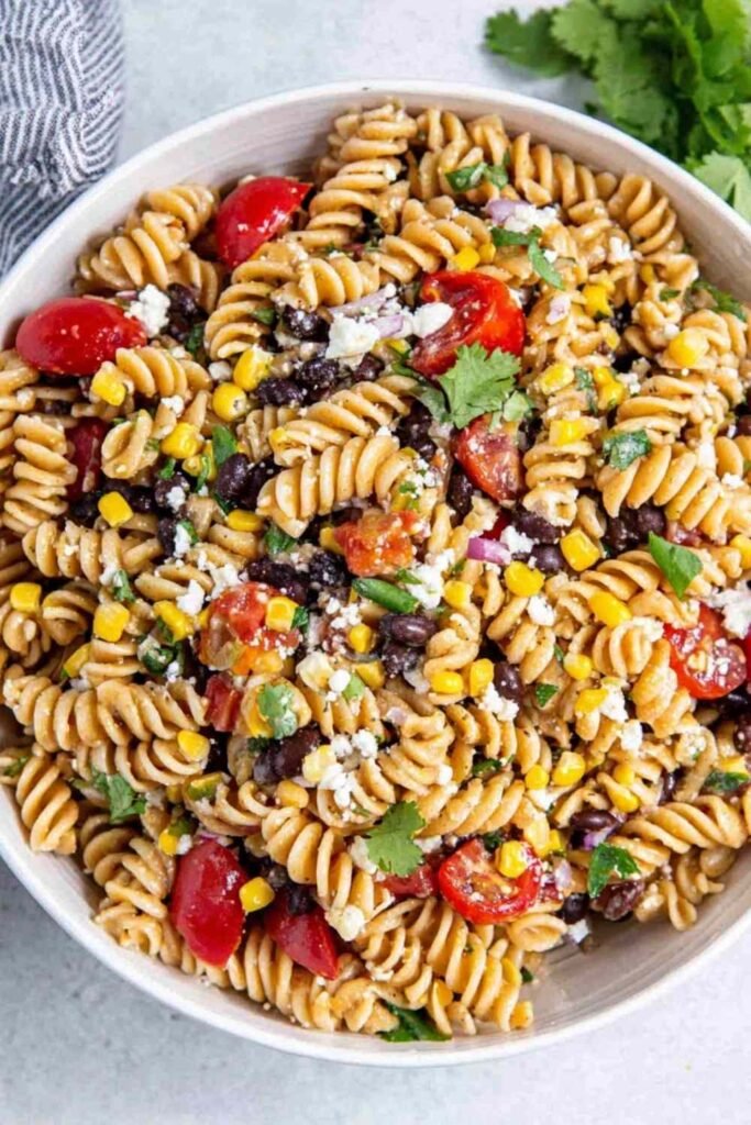 Colorful Southwest Pasta Salad with black beans, corn, tomatoes, and Cotija cheese in a large white bowl