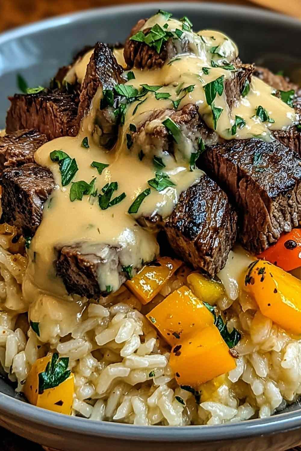 Steak and queso rice served hot in a cast iron skillet topped with fresh cilantro, sour cream, and avocado slices