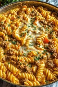 Stovetop creamy ground beef pasta in a large skillet with Parmesan cream sauce and freshly grated Parmesan on top