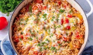 Stuffed pepper casserole in a large skillet topped with melted cheese and fresh parsley