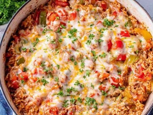 Stuffed pepper casserole in a large skillet topped with melted cheese and fresh parsley