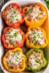Easy stuffed peppers with ground beef and melted cheese in a baking dish