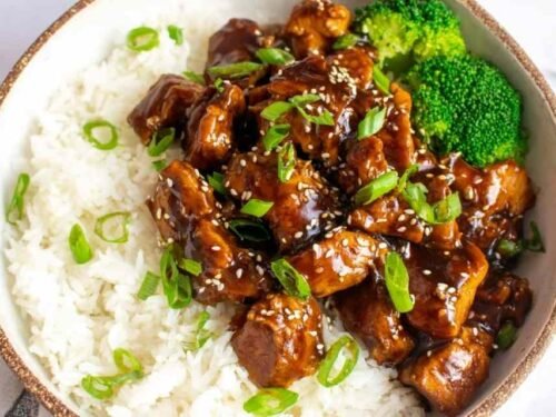 Homemade teriyaki chicken served over white rice with broccoli and sesame seeds