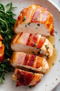 Bacon wrapped chicken breast with maple chili glaze in a baking dish, golden and caramelized
