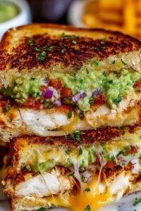 Close-up of a Chicken Avocado Melt Sandwich sliced in half showing melted Swiss cheese and creamy avocado layers on golden sourdough bread