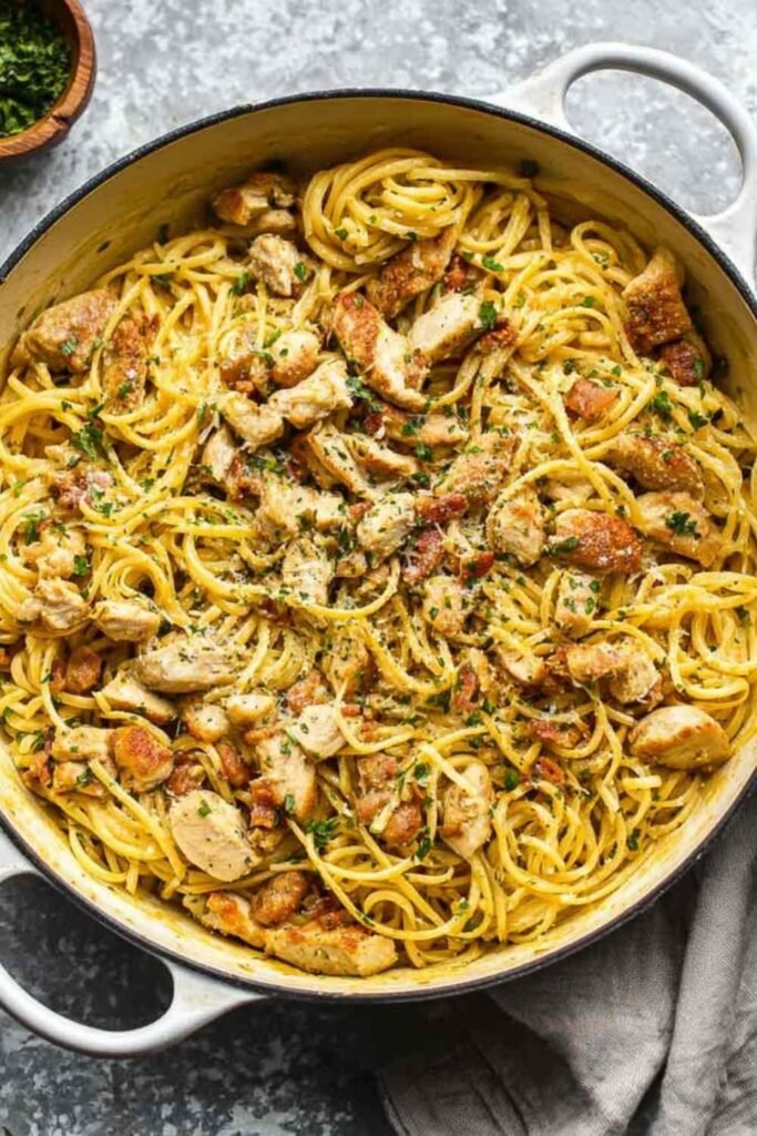 Creamy Chicken Carbonara with spaghetti, crispy bacon, and sliced chicken tenders in a skillet