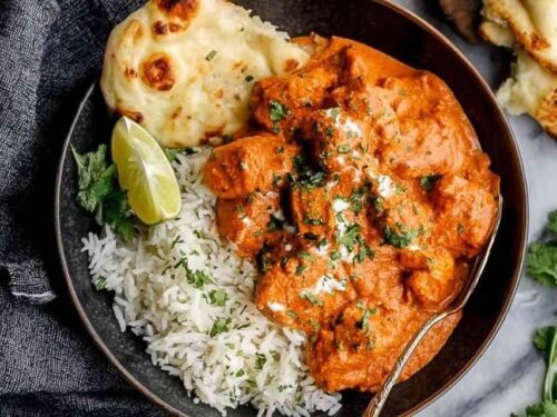 Chicken tikka masala in a non-stick pan with rich creamy orange tomato sauce, tender chicken pieces, and fresh cilantro garnish