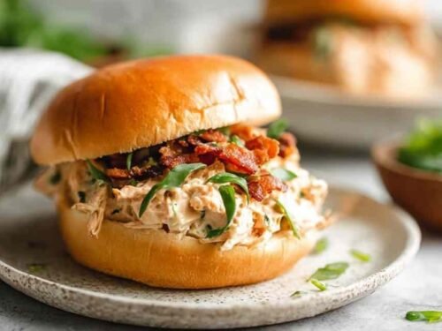 Crockpot Crack Chicken with melted cheddar and crispy bacon inside a slow cooker