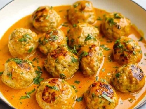 Curry chicken meatballs coated in creamy coconut curry sauce served in a skillet