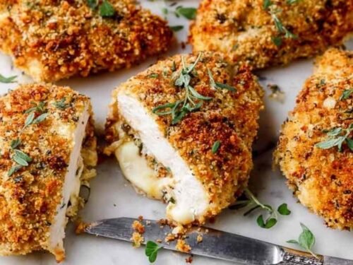 Crispy baked deviled chicken thighs on a white plate with a deep golden Panko Dijon crust and fresh parsley garnish