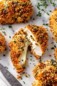 Crispy baked deviled chicken thighs on a white plate with a deep golden Panko Dijon crust and fresh parsley garnish