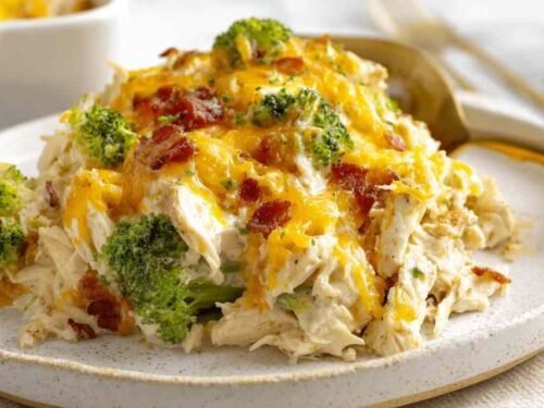 Easy low carb chicken casserole with golden melted cheddar and mozzarella fresh out of the oven in a 9x13 baking dish