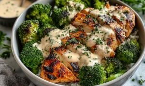 Grilled chicken broccoli bowls with creamy garlic Parmesan sauce served in a white bowl