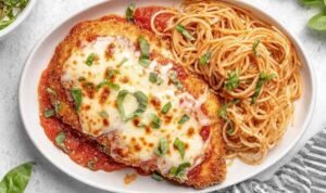 Healthy Baked Chicken Parmesan Healthy Baked Chicken Parmesan cutlets on a baking sheet with bubbly melted mozzarella and marinara sauce fresh from the oven