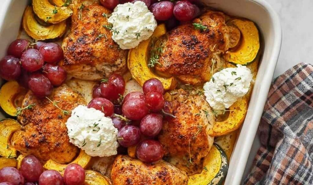 Herb roasted chicken with grapes, acorn squash, and ricotta served in a white baking dish