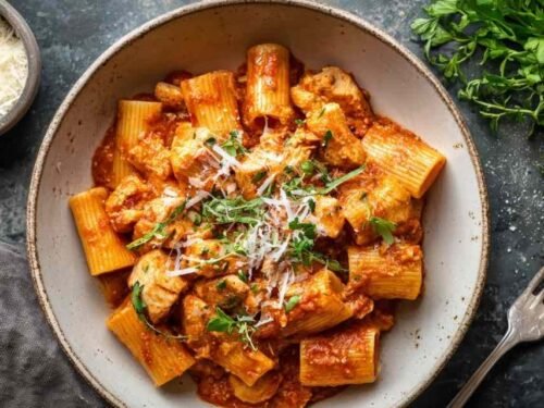 Instant Pot chicken parmesan pasta in an Instant Pot with melted mozzarella and Parmesan cheese and fresh basil garnish