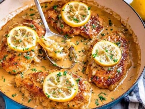 One-pan Chicken Francese with golden egg-coated chicken simmering in a lemon butter sauce in a cast-iron skillet