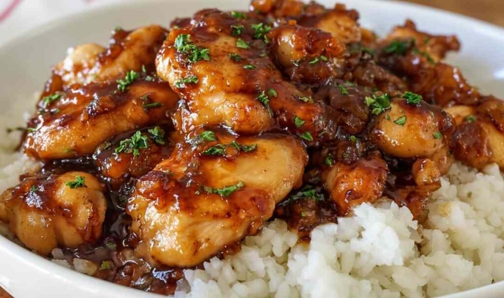 Sticky Honey Butter Chicken in a skillet coated in a rich honey garlic glaze garnished with fresh parsley